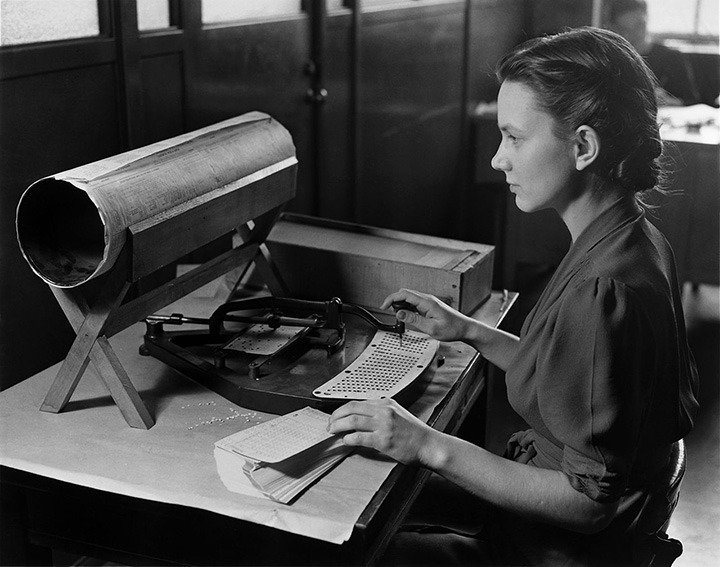 A woman uses a Hollerith card punch machine for the 1940 census. NARA/Wikimedia Commons
